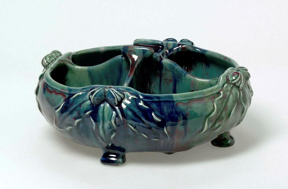 Artwork Nut bowl this artwork made of Earthenware, hand-built low circular bowl on four feet, divided into four compartments with a central support for the nut cracker. Four groups of chestnuts and leaves applied to the exterior and glazed blue, and maroon, created in 1926-01-01