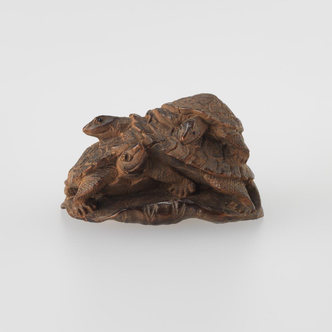 Artwork Netsuke:  (three tortoises on a lotus leaf) this artwork made of Carved wood with ivory inset in base