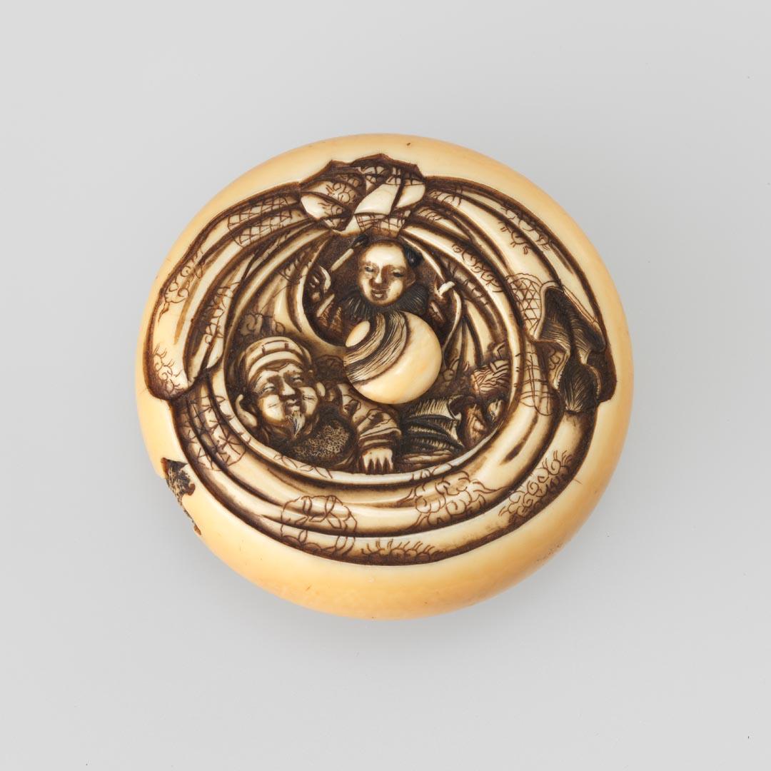 Artwork Netsuke:  (manju (button)) this artwork made of Carved ivory with two figures among patterned drapery.  The reverse with a pouch and foliage.  Movable central fixture with rust cord, created in 1828-01-01