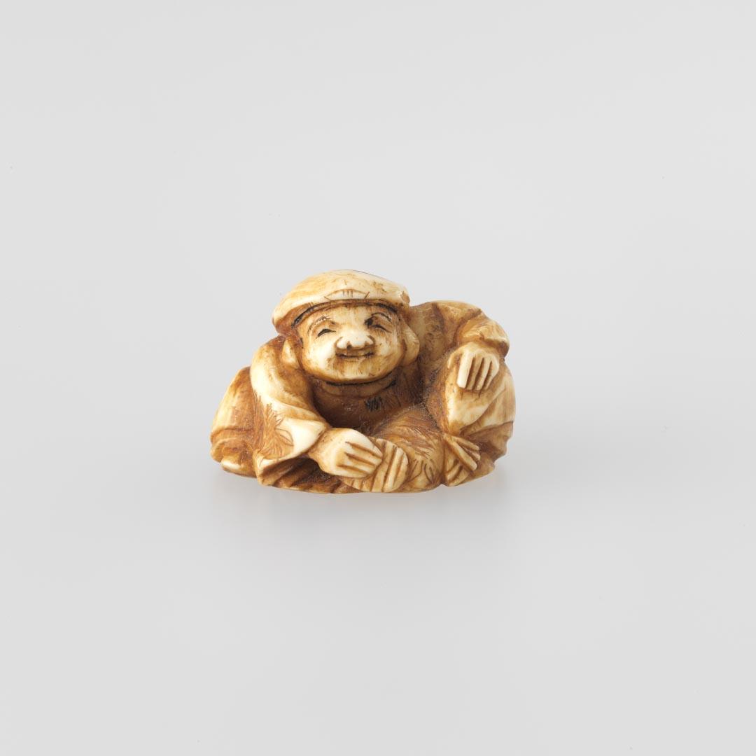 Artwork Netsuke:  (Daikoku (one of the seven dieties of good fortune)) this artwork made of Carved ivory, created in 1800-01-01