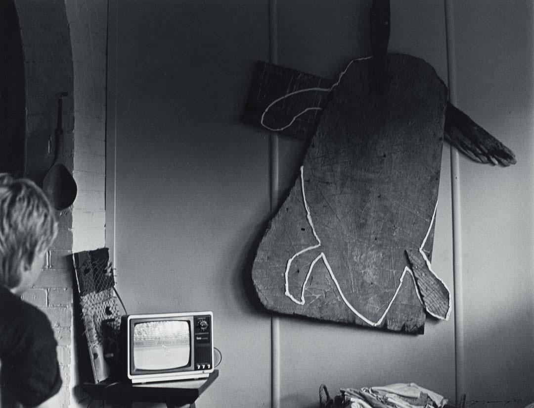 Artwork 14 January 1987, Atherton - Tom Risley had hung a sculpture on his wall. His son Jeff watched test cricket on T.V. (from 'Journeys north' portfolio) this artwork made of Gelatin silver photograph on paper, created in 1987-01-01