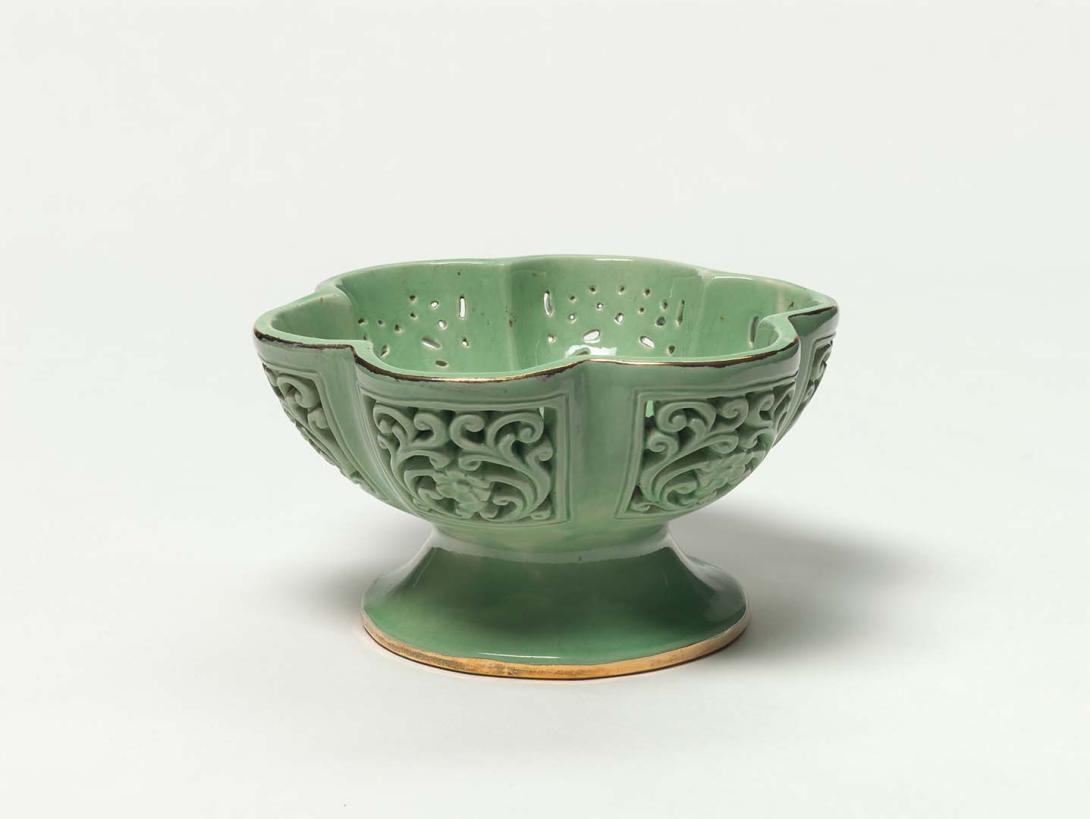 Artwork Lobed fruit bowl this artwork made of Hand-built earthenware footed bowl with six lobes in the rim and carved with foliate panels.  Glazed light green with gilt details, created in 1950-01-01