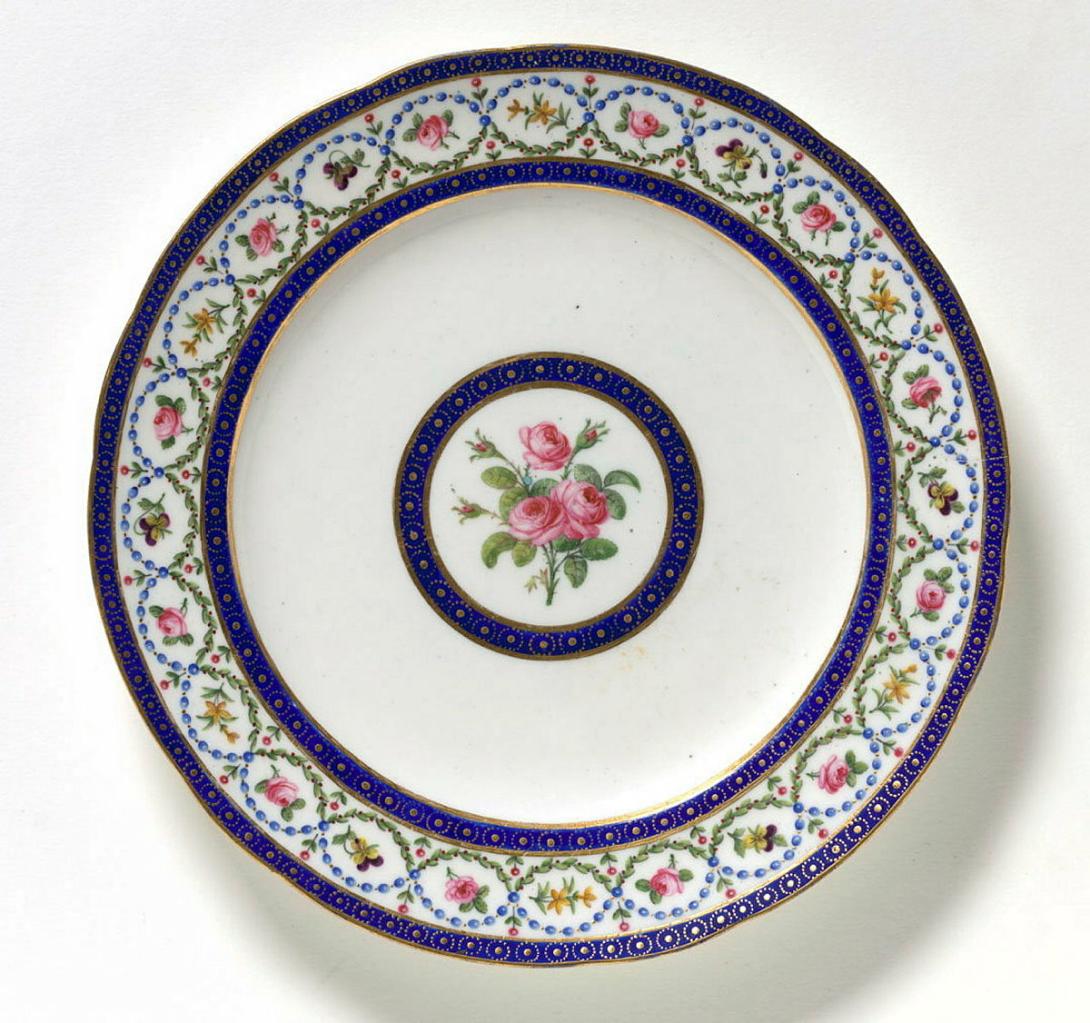 Artwork Plate this artwork made of Soft-paste porcelain, lobed plate with blue oeil-de-perdrix bands enclosing the rim, decorated with floral sprigs within chains, and a central spray of roses, created in 1793-01-01