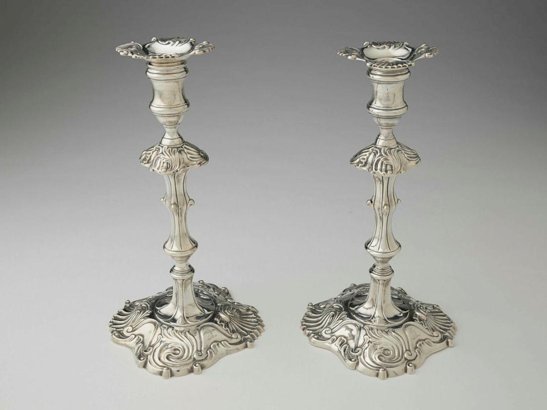 Artwork Candlesticks with drip pans this artwork made of Silver decorated with cast scrolls and shells on the base, knop and drip pan. Engraved with heraldic crest, created in 1751-01-01