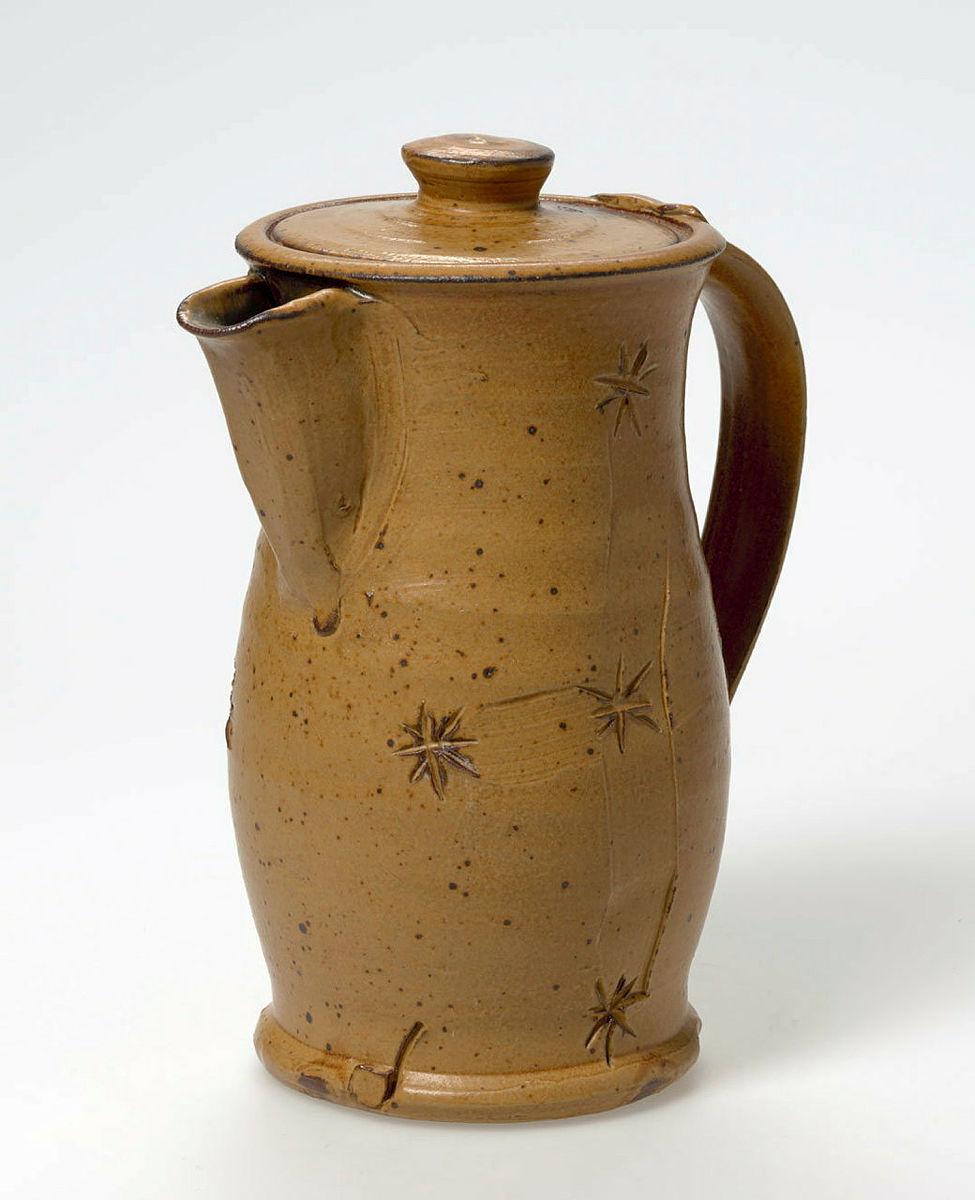 Artwork Coffeepot this artwork made of Stoneware, thrown grey bodied clay incised on both sides with an Eureka flag motif and khaki glaze, created in 1980-01-01