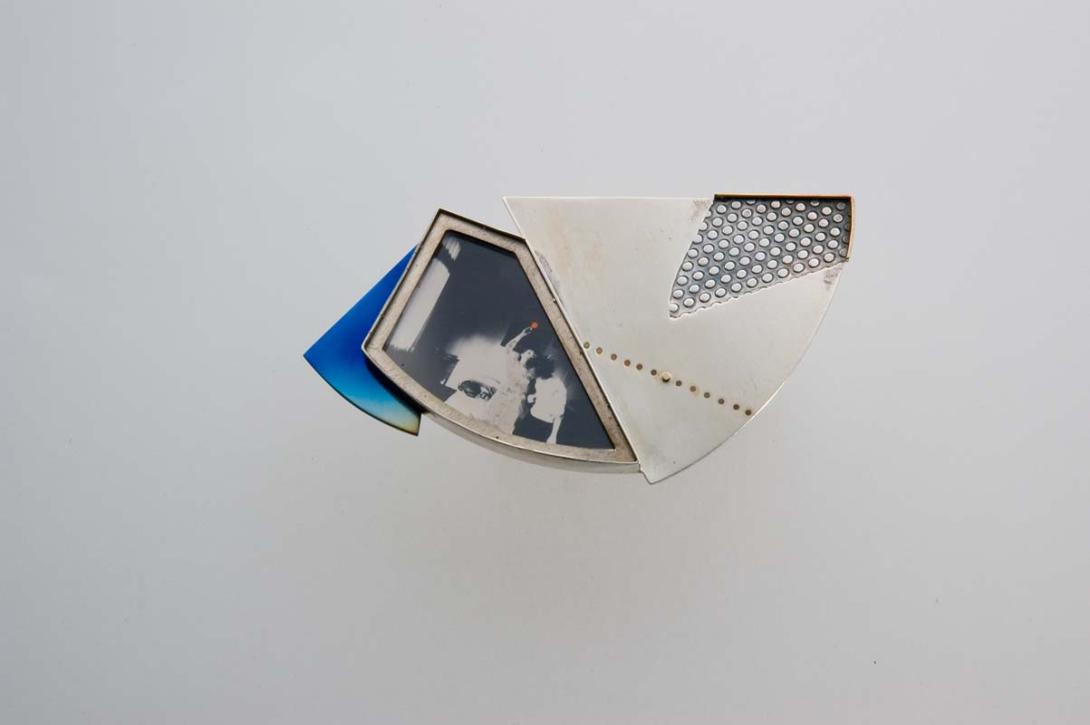 Artwork Brooch:  Event in the room this artwork made of Sterling silver, titanium, gold and photograph beneath perspex, created in 1985-01-01