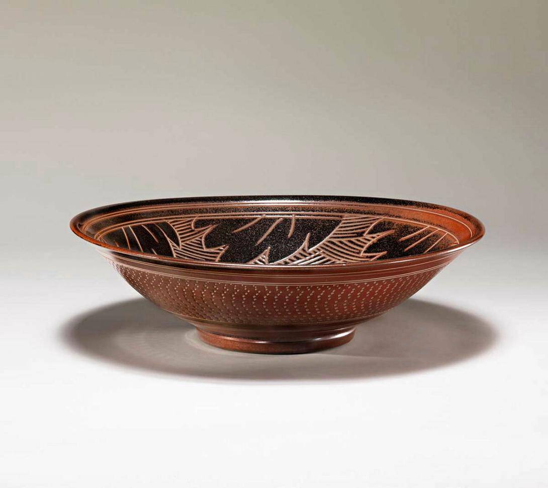 Artwork Large bowl with 'Pinjarra plum' glaze this artwork made of Stoneware, wheelthrown with circular design of incised leaves and 'Pinjarra plum' (reduced iron) glaze, created in 1970-01-01