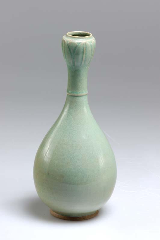 Artwork Bottle this artwork made of Elongated stoneware pear-shaped bottle with single ridge around base of neck, and bulb-shaped neck in the form of a lotus bud; celadon glaze, created in 1920-01-01