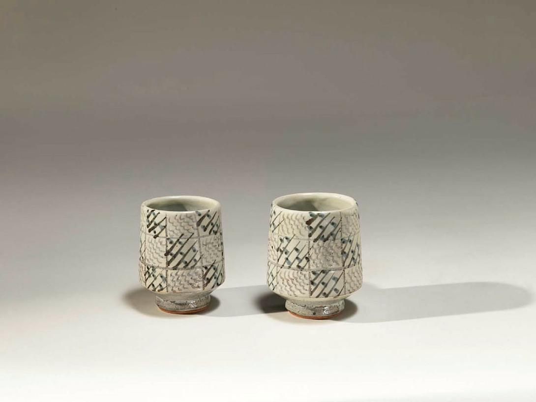 Artwork Pair of teacups this artwork made of Stoneware, wheelthrown and incised with a grid design with cobalt and iron oxide brush over hakeme slip, created in 1973-01-01