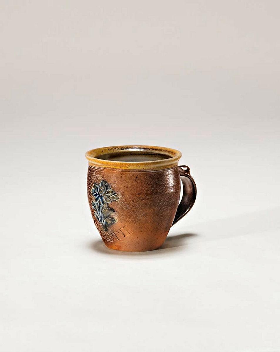 Artwork Coffee mug this artwork made of Stoneware, wheelthrown and sprigged with Carl McConnell flower motif and impressed 'EARTH'. Iron oxide brush with cobalt details and salt glaze