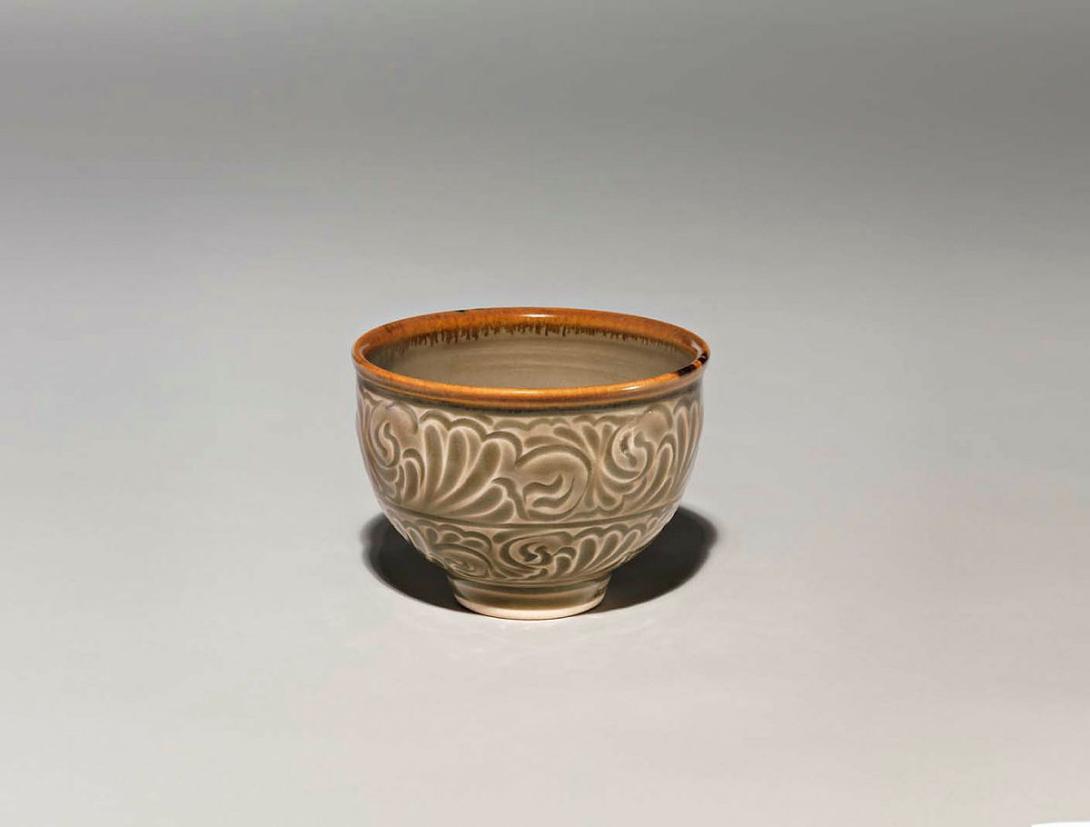 Artwork Tea bowl this artwork made of Porcelain, wheelthrown with Carl McConnell moulded dragon and pearl emblem in well, carved exterior and iron oxide brush and celadon glaze