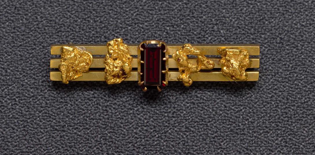 Artwork Goldfields bar brooch (three bars with four nuggets and garnet) this artwork made of Gold, gold nuggets and garnet, created in 1880-01-01
