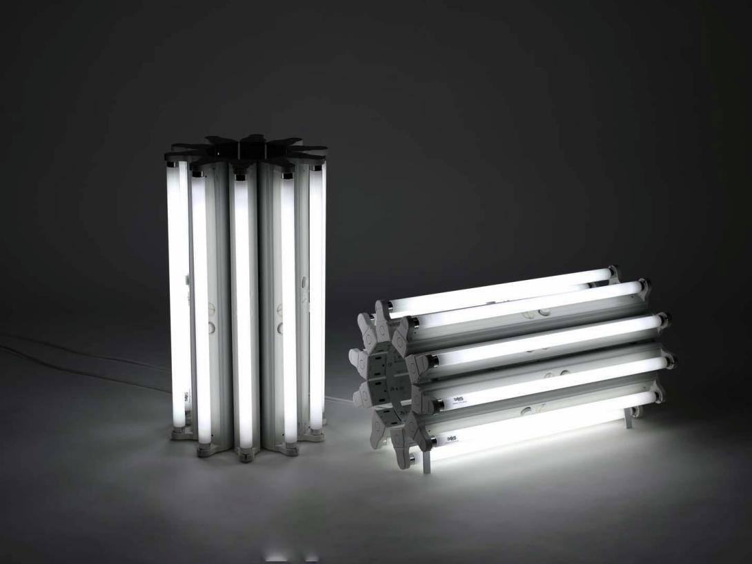 Two brightly lit structures constructed from fluorescent tubes with fittings, electrical cords and cable ties