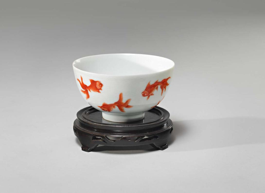 Artwork Bowl with goldfish this artwork made of Porcelain, iron red enamel, incised with wave pattern on lacquered wooden base, created in 1800-01-01