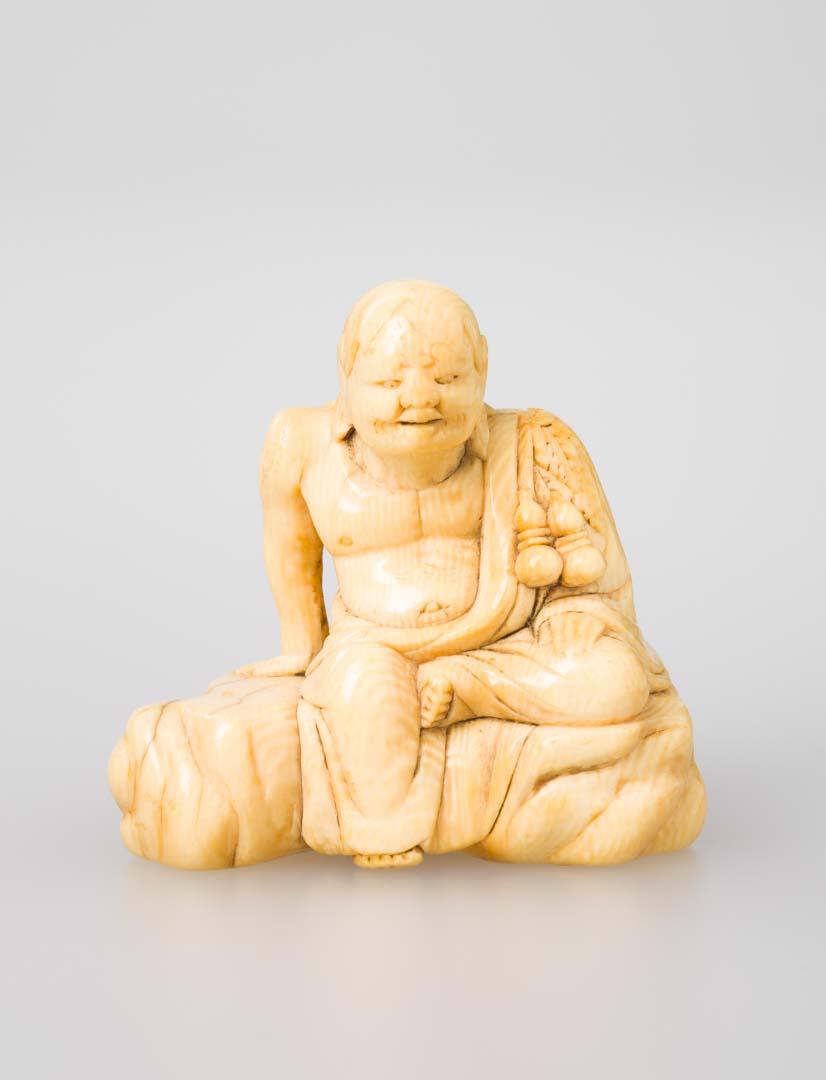 Artwork Netsuke: (sitting figure) this artwork made of Carved ivory, created in 1800-01-01