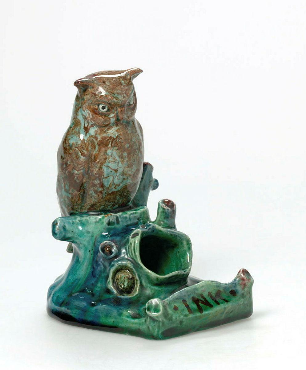 Artwork Inkwell this artwork made of Earthenware, modelled in the form of a hollow log with an owl (in mixed clay) and bush creatures. Inlaid with 'INK' and glazed green, created in 1920-01-01