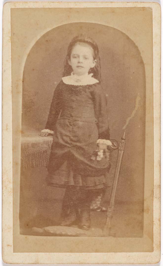 Artwork (Young girl standing on chair) this artwork made of Albumen photograph on paper mounted on card, created in 1872-01-01