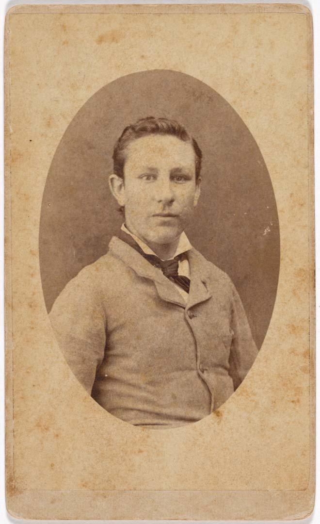 Artwork (Young man in buttoned coat) this artwork made of Albumen photograph on paper mounted on card, created in 1884-01-01
