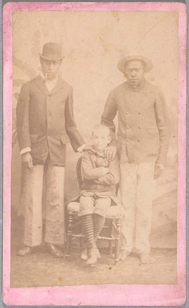 Artwork Two New Caledonian men and European boy this artwork made of Albumen photograph on paper mounted on card, created in 1865-01-01