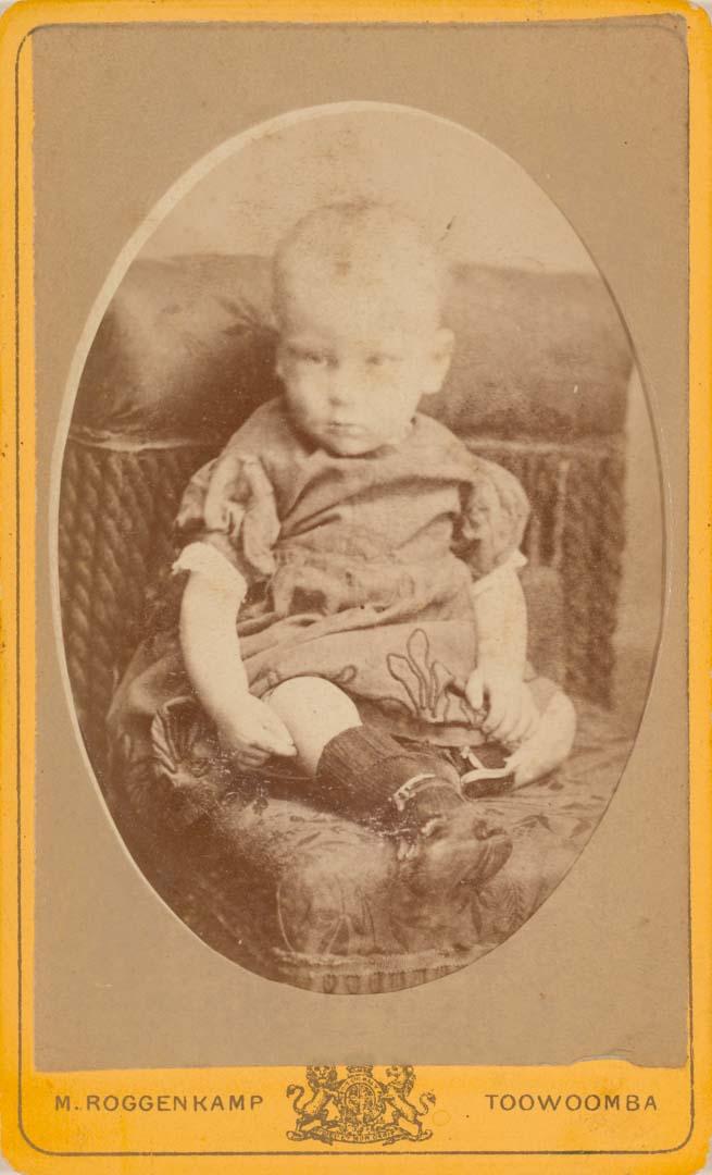 Artwork (Young child seated on chair, Toowoomba) this artwork made of Albumen photograph on paper mounted on card