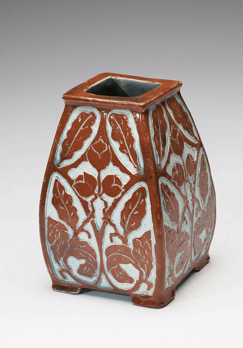 Artwork Vase this artwork made of Earthenware, slab built dipped red slip and carved with a design of leaves and nuts. Light blue glaze, created in 1933-01-01