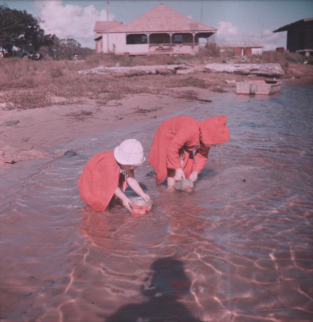Artwork (Two small girls in red, filling sand buckets in shallow water) this artwork made of Cellulose acetate Dufay colour transparency (originally in a glass mount)