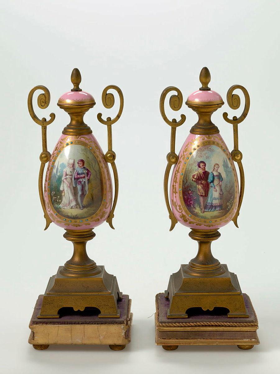 Artwork Garniture (pair) this artwork made of Porcelain and gilt bronze painted in overglaze colours with 18th century revival courtship scenes. Gilt details, created in 1880-01-01