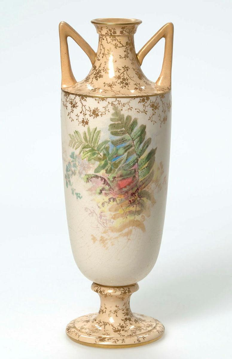 Artwork Vase this artwork made of Porcelain urn shaped vase transfer printed with leaves and ferns and hand coloured.  Gilt floral details on apricot ground on neck and foot.  Dull gilt sprayed rim and handles, created in 1891-01-01