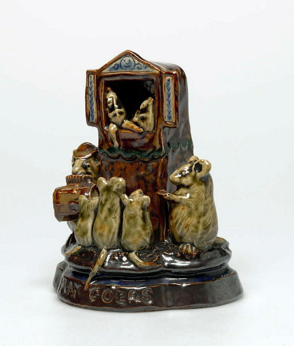 Artwork Ornament:  Playgoers this artwork made of Stoneware, modelled as a group of three mice watching a Punch and Judy show and flanked by a musician and coin collector.  Salt glazed, created in 1884-01-01