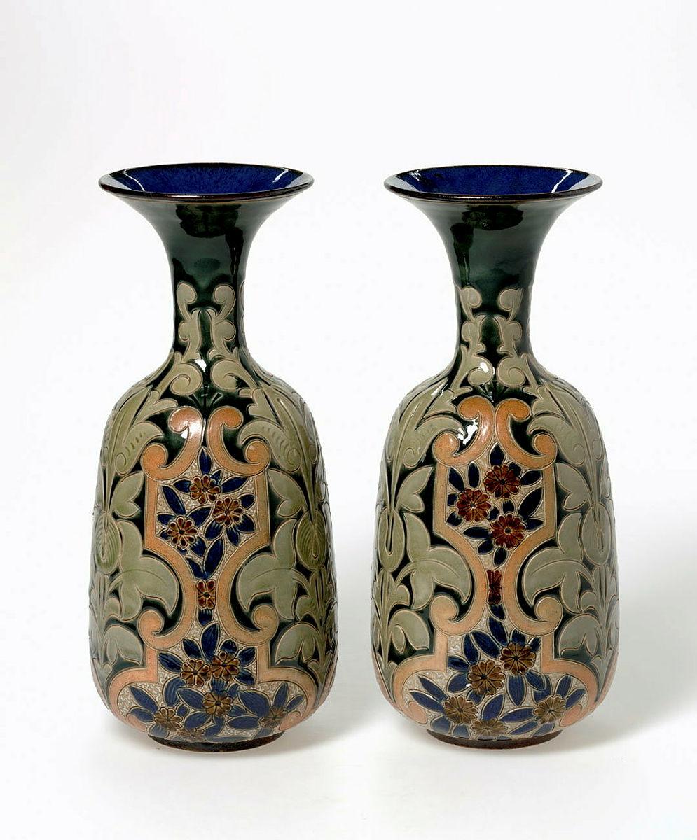 Artwork Pair of vases this artwork made of Stoneware with oblong body narrow neck and everted rim.  Decorated with a Persian (?) floral motif in blue, green and brown.  Saltglazed, created in 1883-01-01