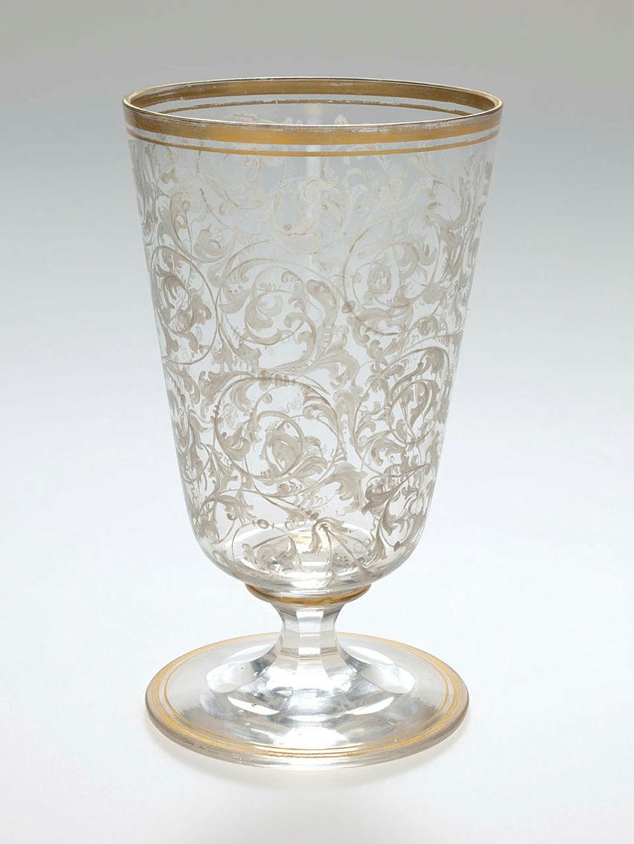 Artwork Goblet this artwork made of Clear glass painted in white with small foliate motifs covering the surface. Gilt rim., created in 1840-01-01