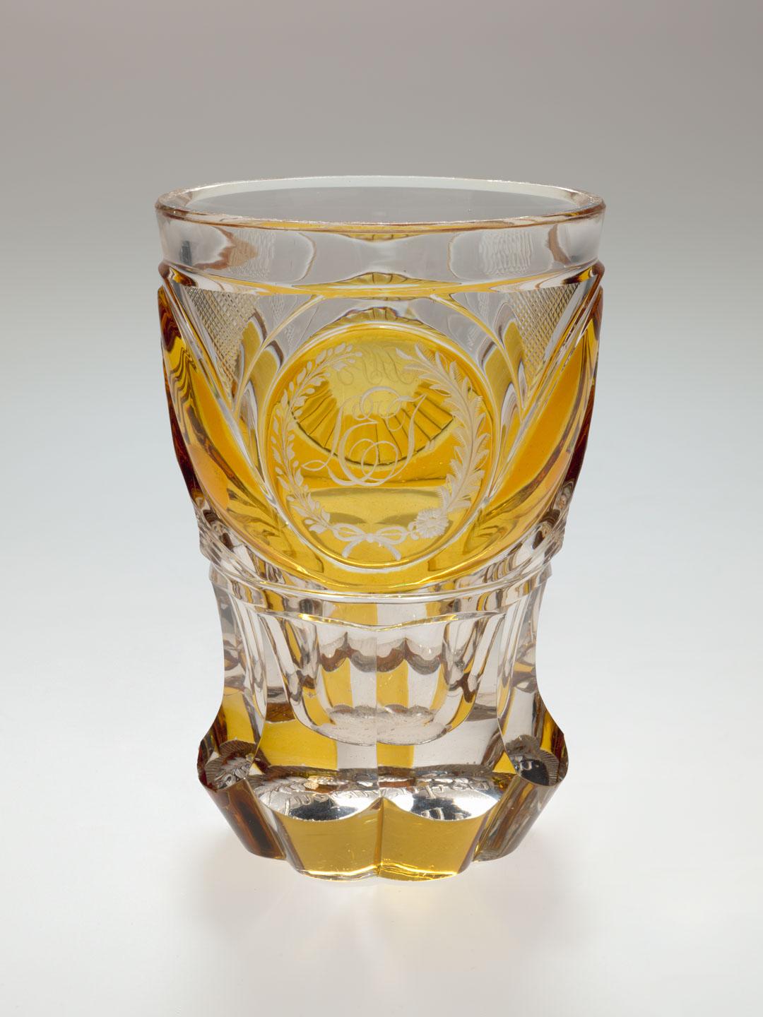Artwork Beaker this artwork made of Clear glass stained yellow and wheelcut with facets and ridged circular motifs, created in 1840-01-01