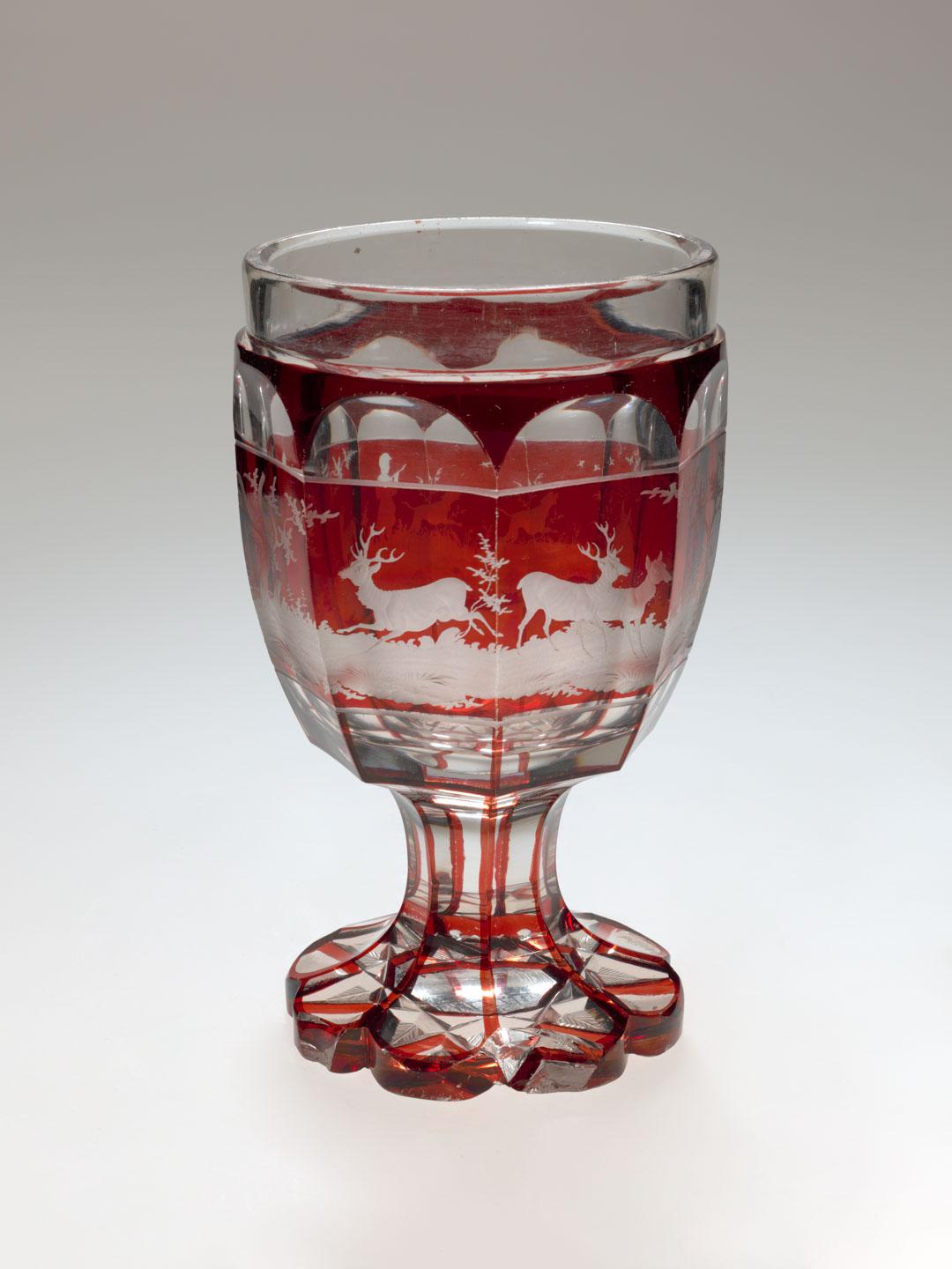 Artwork Goblet this artwork made of Clear glass stained red and engraved with a hunting scene;  star pattern on base, created in 1840-01-01