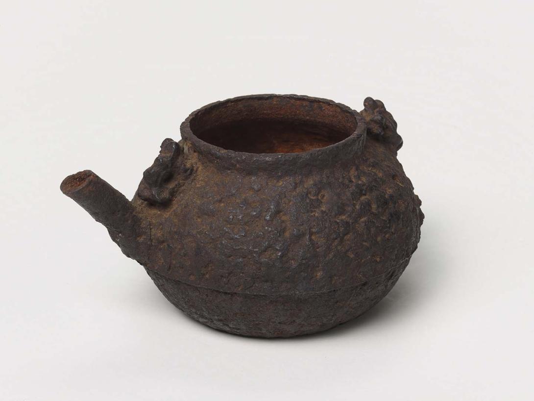 Artwork Winepot this artwork made of Black cast iron flattened spherical shape with coarse texture and dragon mask handles, created in 1800-01-01