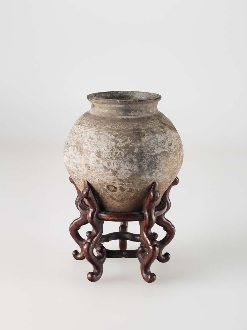 Artwork Vase this artwork made of Grey stoneware clay of swelling form with a floral band in relief beneath the neck.  Underglazed and with wooden stand, created in 0900-01-01